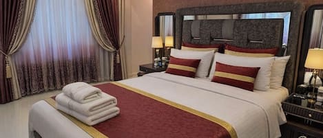 Une chambre d’hôtel moderne équipée d’un grand lit, d’une table de chevet, d’un climatiseur et d’un miroir.
