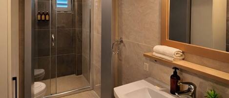 A modern bathroom with a shower, toilet, and vanity.