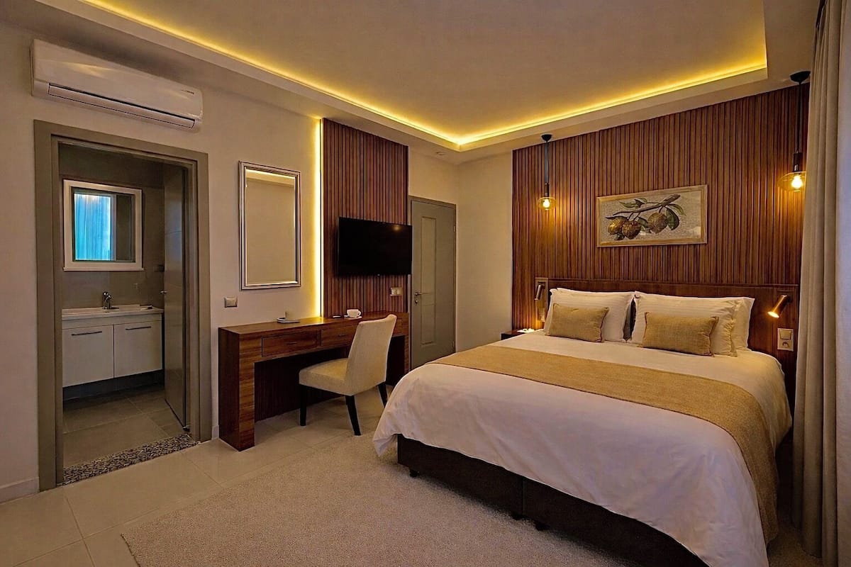 Une chambre d’hôtel moderne équipée d’un lit, d’un bureau et d’une télévision.
