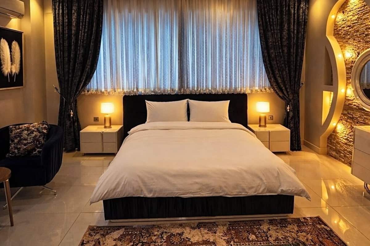Une chambre moderne avec un grand lit, deux tables de chevet, un tapis décoratif et un motif mural original.