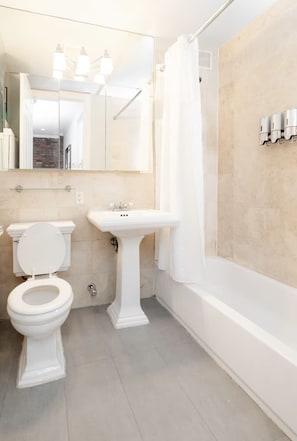 A bathroom with a toilet, sink, and bathtub.