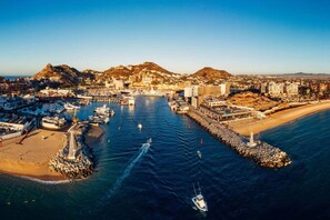 An aerial view of a coastal town with a marina, buildings, and a mountain in the background. - Nauti Baja- Condo at The Marina/Near the Beach! (Cabo San Lucas)