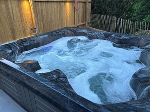 A hot tub with a wooden fence and a wooden deck in the background. - Mawddach View in Snowdonia with Hot tub, pet friendly & great location (Barmouth)