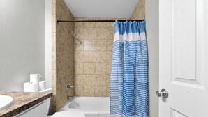 A bathroom with a toilet, a bathtub, and a shower curtain. - 1Br 1Bath Long Stays Near Fort Moore (Columbus)
