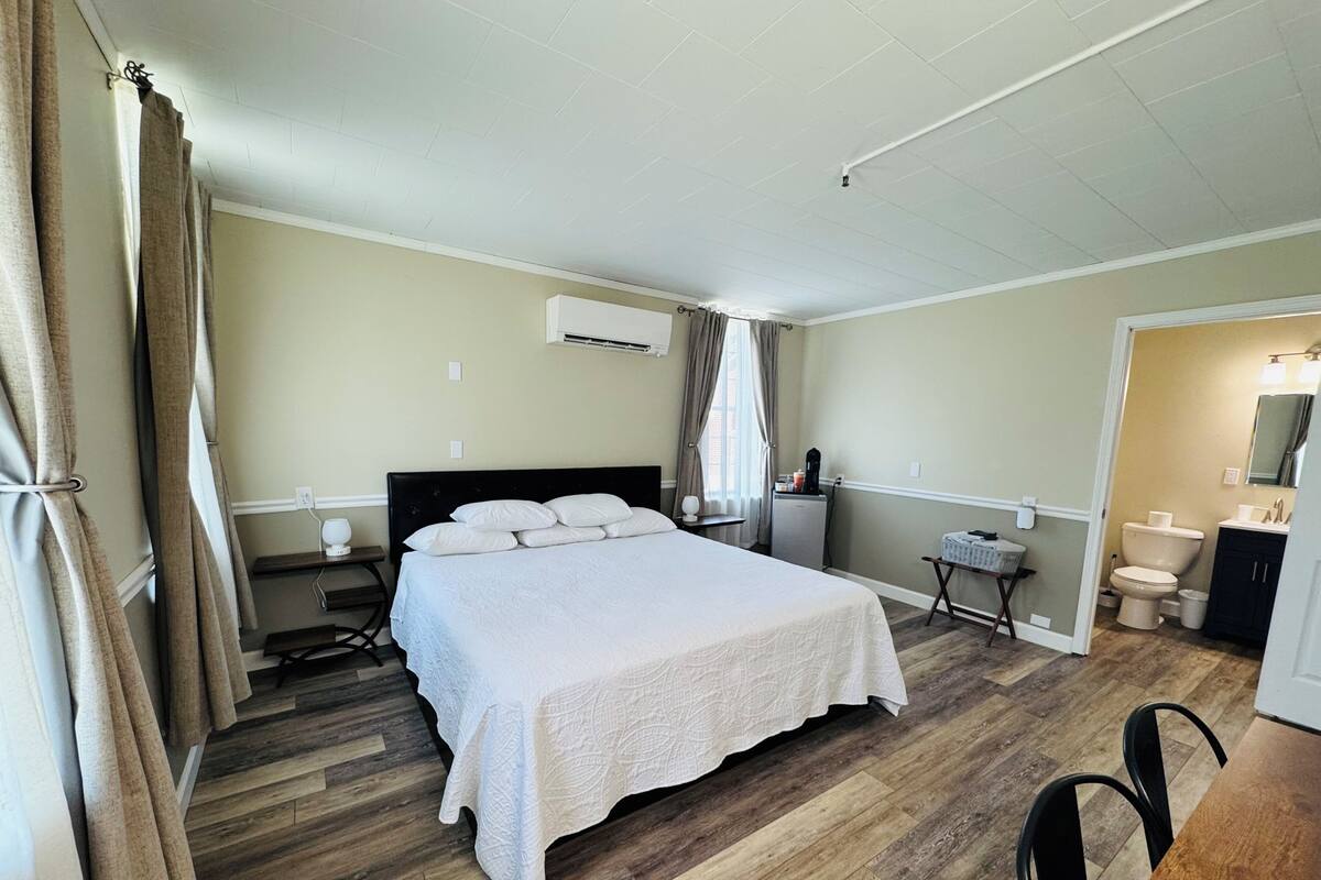Una camera da letto con un letto, un comodino e un tavolino con una lampada.