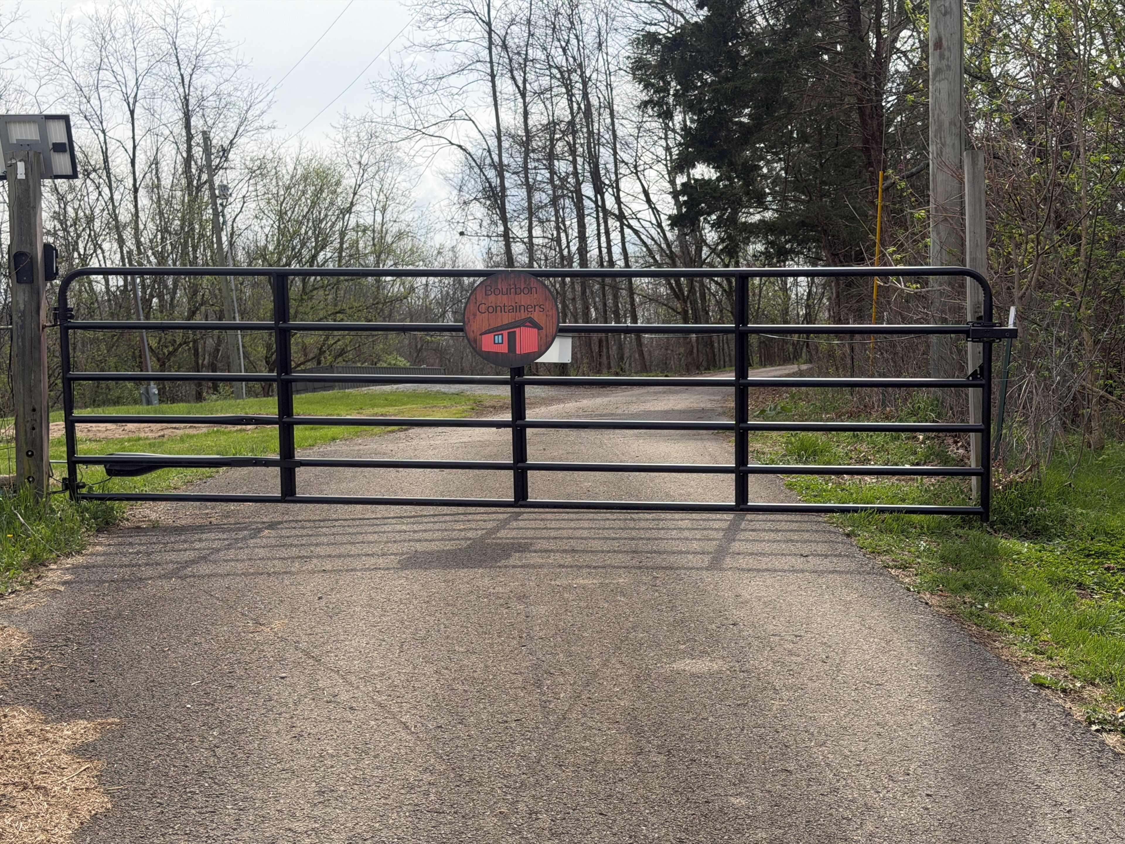 A gated entrance with a sign for Bourbon Containers.
