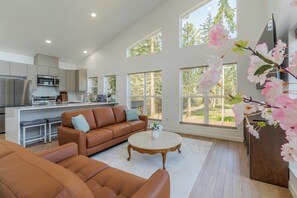 A modern kitchen with a dining area, a sofa, and a coffee table. - Stunning ocean-view cottage minutes from Olympic (Port Angeles)