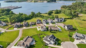 Een woonwijk met huizen, een weg en een meer.