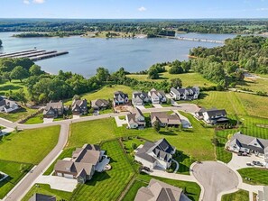 A residential area with houses, a lake, and a bridge. - The Bourbon Embassy at Twin Creeks (Winchester)