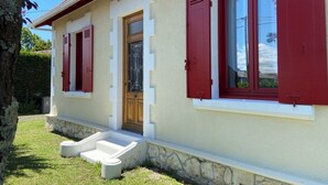 A house with a stone foundation, a front door, and red shutters. - Gite la Pinassotte - GUJAN-MESTRAS (GUJAN-MESTRAS)