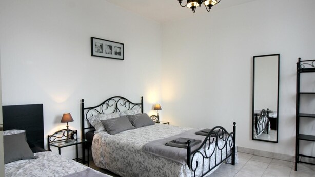 A bedroom with two beds, a chandelier, bedside lamps, a mirror, and a framed picture on the wall. - Gite la Pinassotte - GUJAN-MESTRAS (GUJAN-MESTRAS)