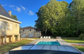 A swimming pool with lounge chairs and a covered deck area. - La Ruche - CAMBES - Gîte (CAMBES)