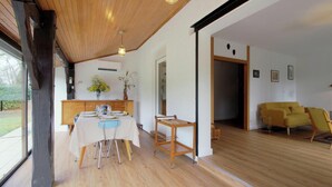 A modern interior with a dining area, wooden flooring, and a yellow sofa. - Gîte du Pitchouret - BELIN BELIET (BELIN BELIET)