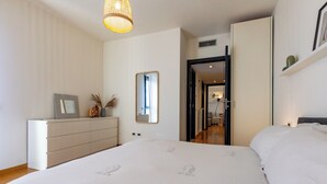 A bedroom with a bed, dresser, mirror, and a hanging light fixture. - Pavese by Wynwood House (Milan)