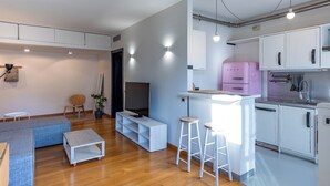 A modern kitchen with white cabinets, a pink refrigerator, and a bar area. - Pavese by Wynwood House (Milan)