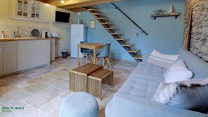 En hyggelig indretning med et køkken, spiseplads og en trappe til en etage ovenpå.
