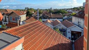 Un balcon donnant sur un quartier résidentiel, avec vue sur des maisons et un ciel dégagé.