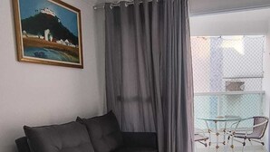 Una sala de estar moderna con un sofá, una mesa de comedor y un cuadro en la pared.