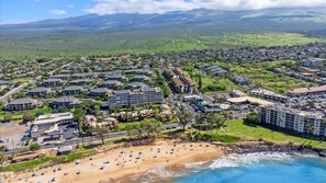 Ein Luftbild eines Küstenresorts mit mehreren Hotelgebäuden, einem Sandstrand und freiem Blick auf den Ozean.
