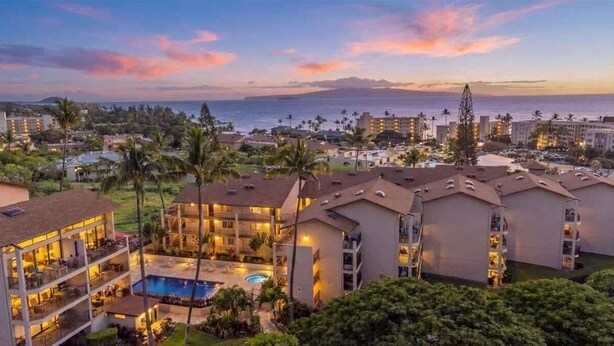 A resort with multiple buildings, a swimming pool, and a view of the ocean. - 2 bedroom updated Kihei condo, AC, walk to beach, shops, & dining (Kihei)