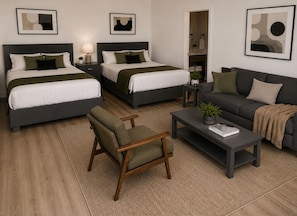 Une chambre d’hôtel avec deux lits, un canapé, un fauteuil et une table basse.