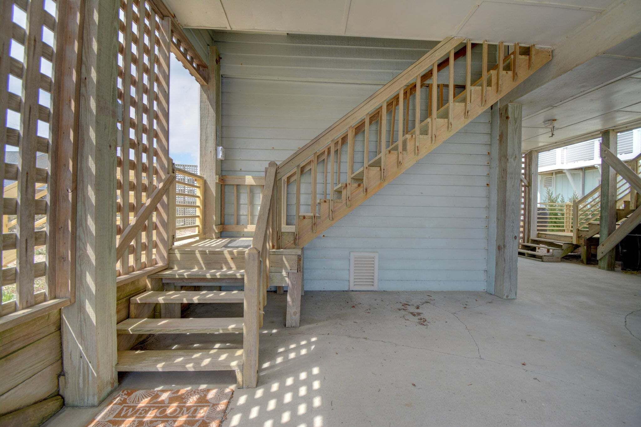 A wooden staircase with a metal railing, leading to an upper level.