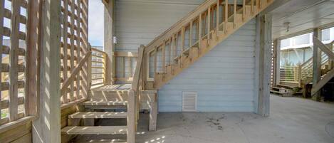 A wooden staircase with a metal railing, leading to an upper level.