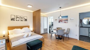 Een moderne hotelkamer met een houten bed, een bureau en een zithoek.