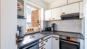 Een moderne keuken met een ingebouwde espressomachine, een vaatwasser en een oven.