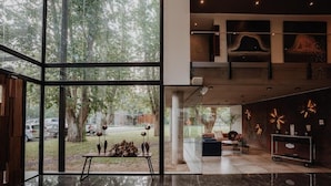 A modern interior with large windows, a reception desk, and a view of the outdoors. - Modern Rio Cuarto Retreat: Spa, Indoor Pool | 10 Min Drive to IAH Airport (Río Cuarto)