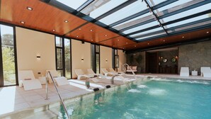 A swimming pool with lounge chairs and a glass ceiling. - City View Escape Near Airport: Free Parking & Daily Breakfast Buffet (Río Cuarto)