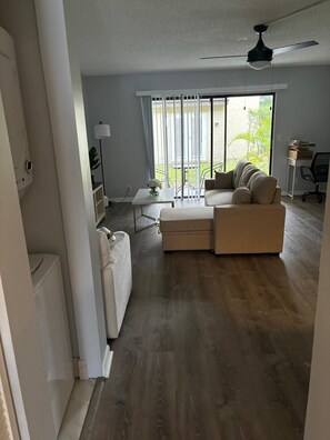 A living room with a sofa, a coffee table, and a ceiling fan. - 2-BR Apt in Deerfield Beach with AC, Free wifi and Free parking near Golf Course (Deerfield Beach)