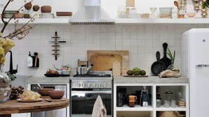 A modern kitchen with white cabinetry, a central island, a stove, and a refrigerator. - open plan contemporary barn in the heart of Daylesford (Daylesford)