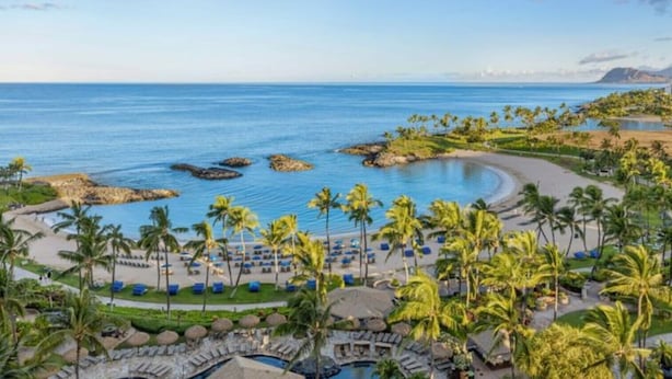 Ein Resort mit Pool, Strand und Palmen.