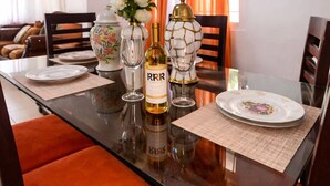 A dining table set with plates, glasses, a bottle, and decorative items.