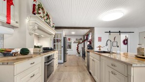 A kitchen with white cabinetry, wooden countertops, and a central island.