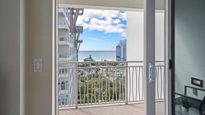 Ein Balkon mit Blick auf eine Stadtlandschaft und das Meer.
