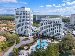 Zwei hohe Hotels mit Pool und Parkplatz.