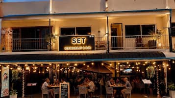 A restaurant with outdoor seating, a sign reading 'SET RESTAURANT & BAR,' and a menu board.