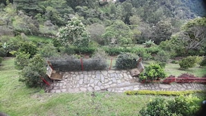 A stone pathway leading to a stone wall with a small garden area. - El Mirador De Serrato (La Vega)