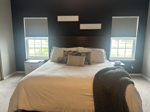 A bedroom with a large bed, two bedside tables, a window, and two wall-mounted signs. - 2-bedroom townhome walking distance to NRG/FIFA World Cup w/ garage. (Houston)