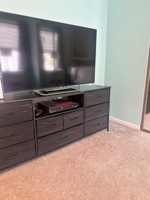 A flat-screen TV on a dark wooden cabinet with drawers, a red game controller, and a mouse. - 2-bedroom townhome walking distance to NRG/FIFA World Cup w/ garage. (Houston)