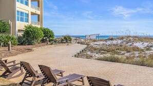 Un hotel sul lungomare con una passeggiata, sdraio e vista sull'oceano.
