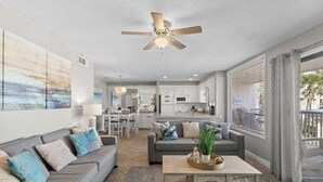 Un soggiorno moderno con divano, tavolino e ventilatore a soffitto.