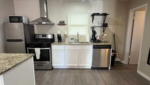 Una cocina moderna con una isla central, electrodomésticos de acero inoxidable y suelo de madera.