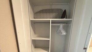 Un armario con estantes, espacio para colgar y una cesta.