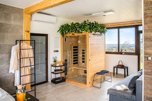 A modern room with a sauna, a wooden bench, a glass door, and a view of the outdoors. - Modern home with jacuzzi, sauna, wellness and kids’ playground (Grabrovnik)