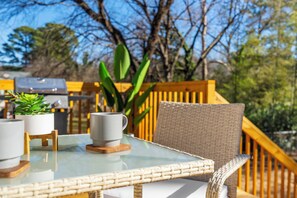 Une table à plateau en verre, avec une tasse blanche et une plante en pot.