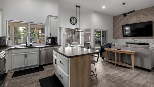 A modern kitchen with a central island, white cabinetry, and a large window. - Modern upgraded 3-bedroom home in sunny Scottsdale! (Scottsdale)