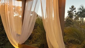 A bed with a canopy, a wooden headboard, and two pillows.